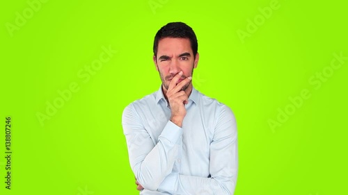 Suspicious young man against green background