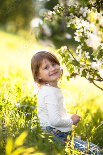  child in white sweater and jeans, spring flowers