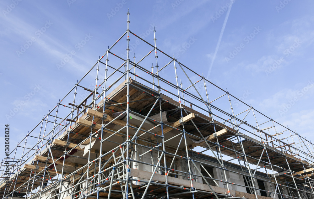 scaffolding on building site of new apartment building and blue sky in holland scaffolding on building site of new apartment building and blue sky in holland