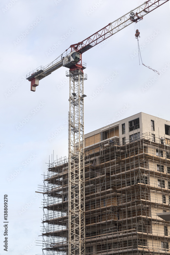 scaffolding on building site of new apartment building and crane scaffolding on building site of new apartment building and crane
