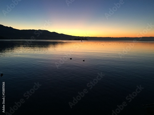 Stimmungsvoller Sonnenuntergang mit Wasserspiegelungen am Z  richsee