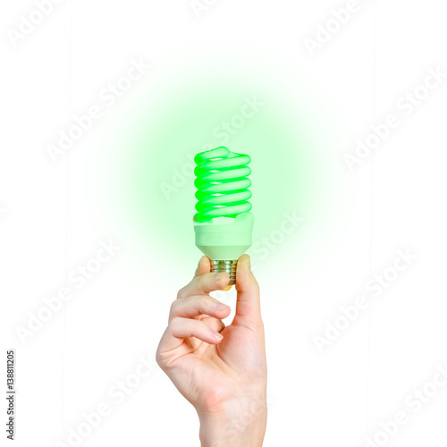 Closeup of man's hand holding energy saving lamp. Glows brightly with green light. Recycling, electricity, environment and ecology concept. The lamp is green. Isolated on white background