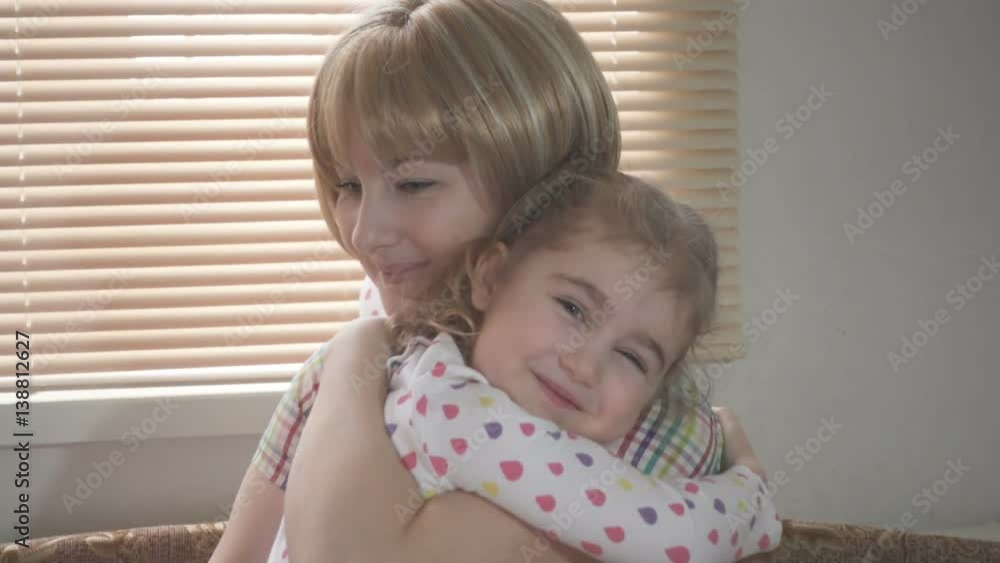 Daughter Rushes Into Mother's Arms At Home Across From the Window. Slow motion. Big Hug Daughter Rushes Into Mother's Arms At Home Across From the Window. Slow motion. Big Hug