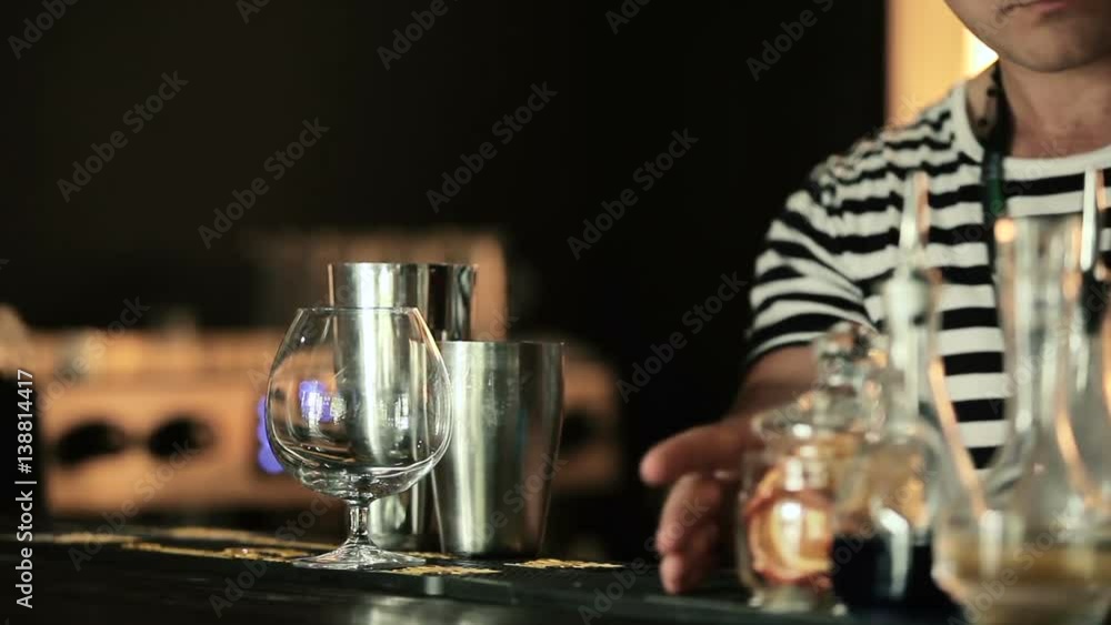 The bartender puts orange slices in a jar. The bartender puts orange slices in a jar.