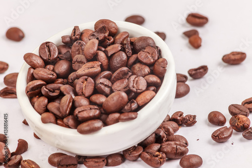 Coffee beans in a bowl on a white background