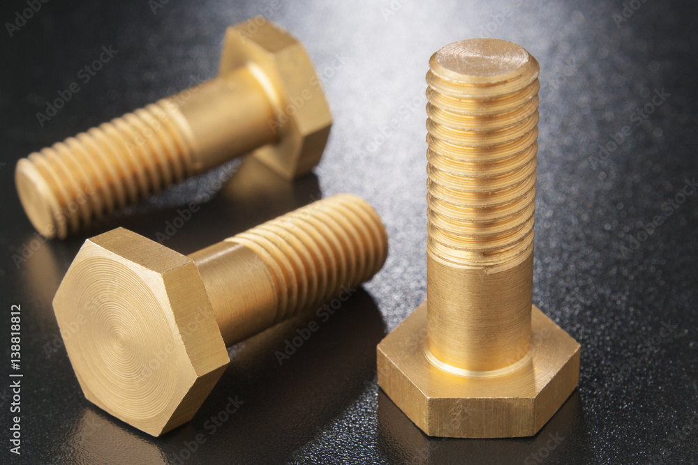 Brass bolts on dark surface. concept of small part of system. Brass bolts on dark surface. concept of small part of system.