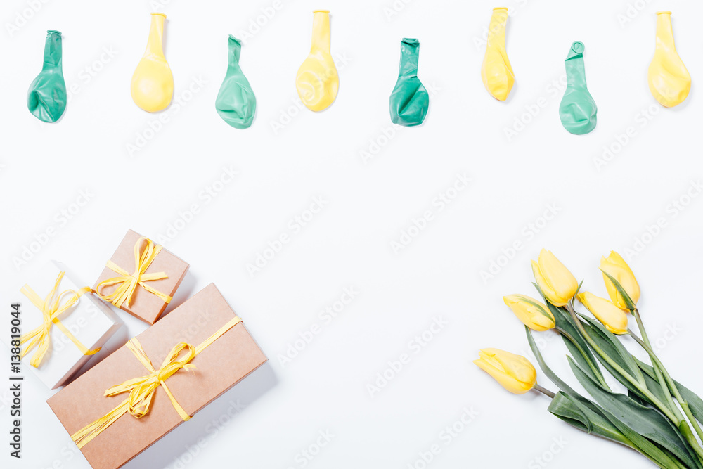 Yellow flowers, gift boxes with bows and balloons on white background Yellow flowers, gift boxes with bows and balloons on white background