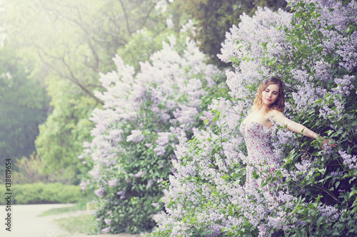 woman enjoying blooming lilac, tinted