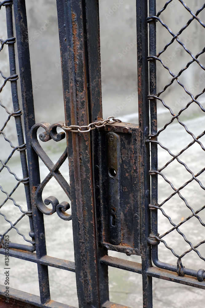 Old rusty gate with broken handle, closed with chain Old rusty gate with broken handle, closed with chain