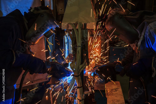 Team welder are welding in car factory