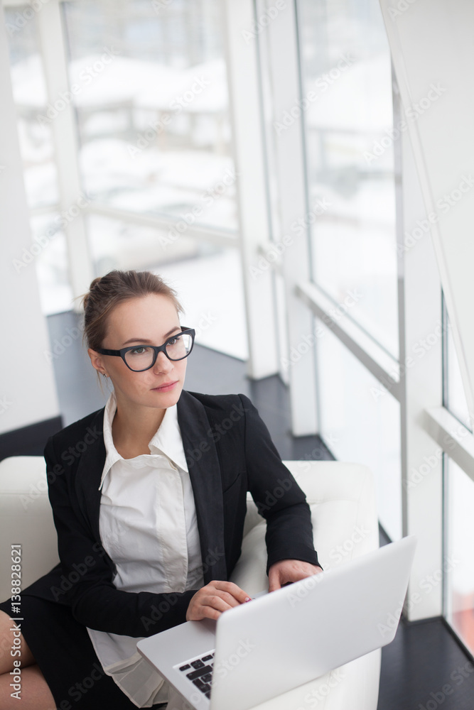 Young woman working at lap top in the office. Young woman working at lap top in the office.