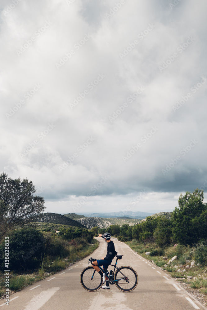 Obraz premium A cyclist pointing on the mountain