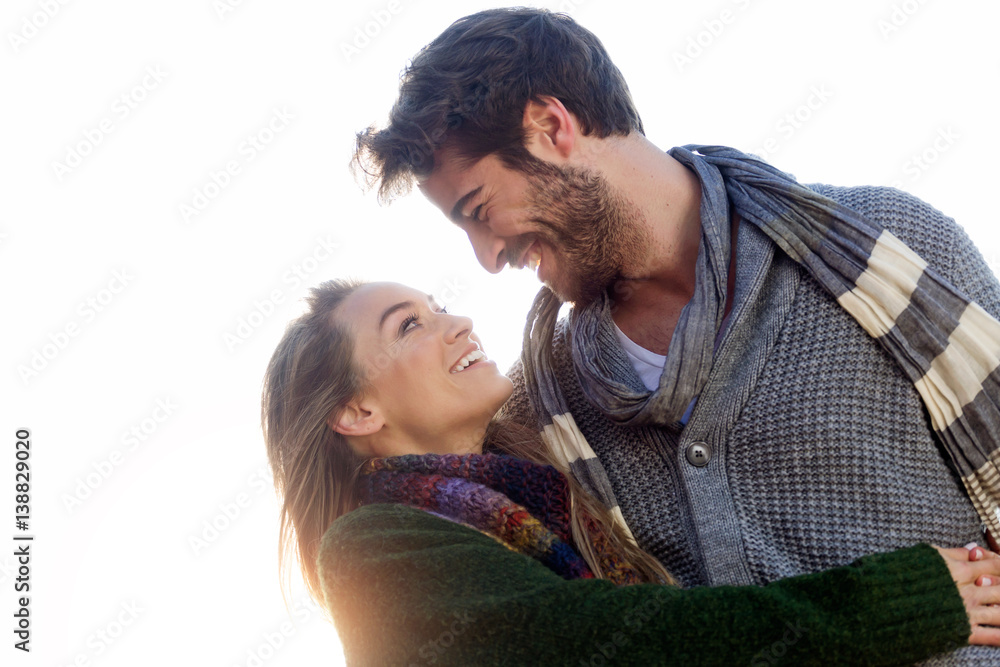 Beautiful young couple in love in a cold winter on the beach.