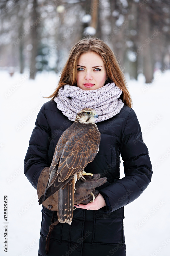 woman holding a falcon Photos | Adobe Stock