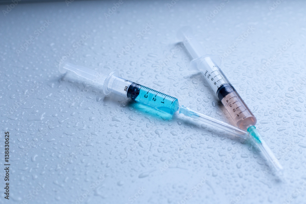 Syringe with solution and have rain drops water on table in Laboratory. Syringe with solution and have rain drops water on table in Laboratory.