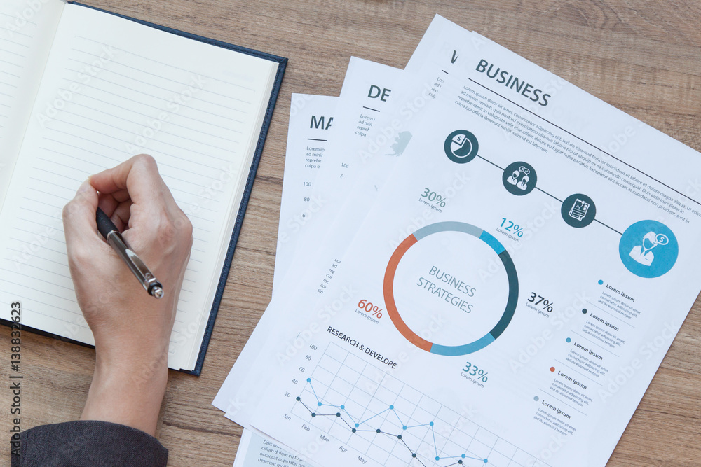 business documents on office table with laptop computer and graph financial diagram and Business people working at office business documents on office table with laptop computer and graph financial diagram and Business people working at office