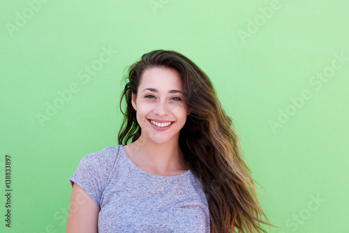 smiling young woman standing against green background