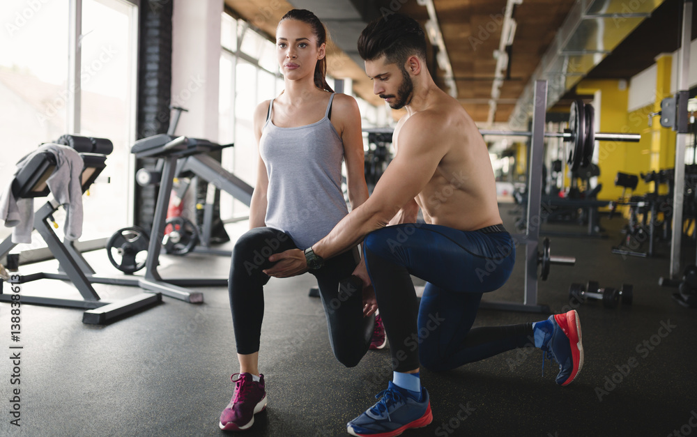 Personal trainer assisting woman lose weight