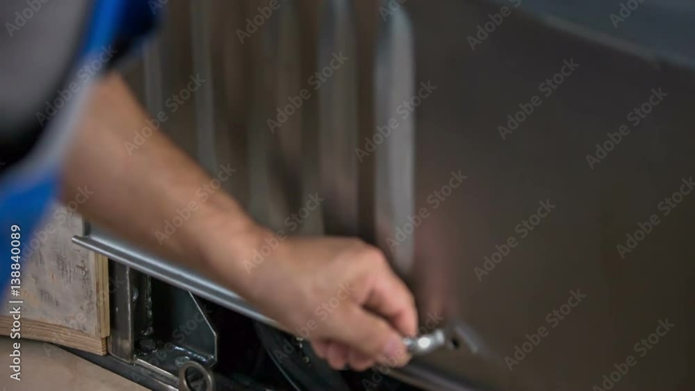 A man is closing the engine of the car and he is also locking it. He is making a new wooden car.
A man is closing the engine of the car and he is also locking it. He is making a new wooden car.