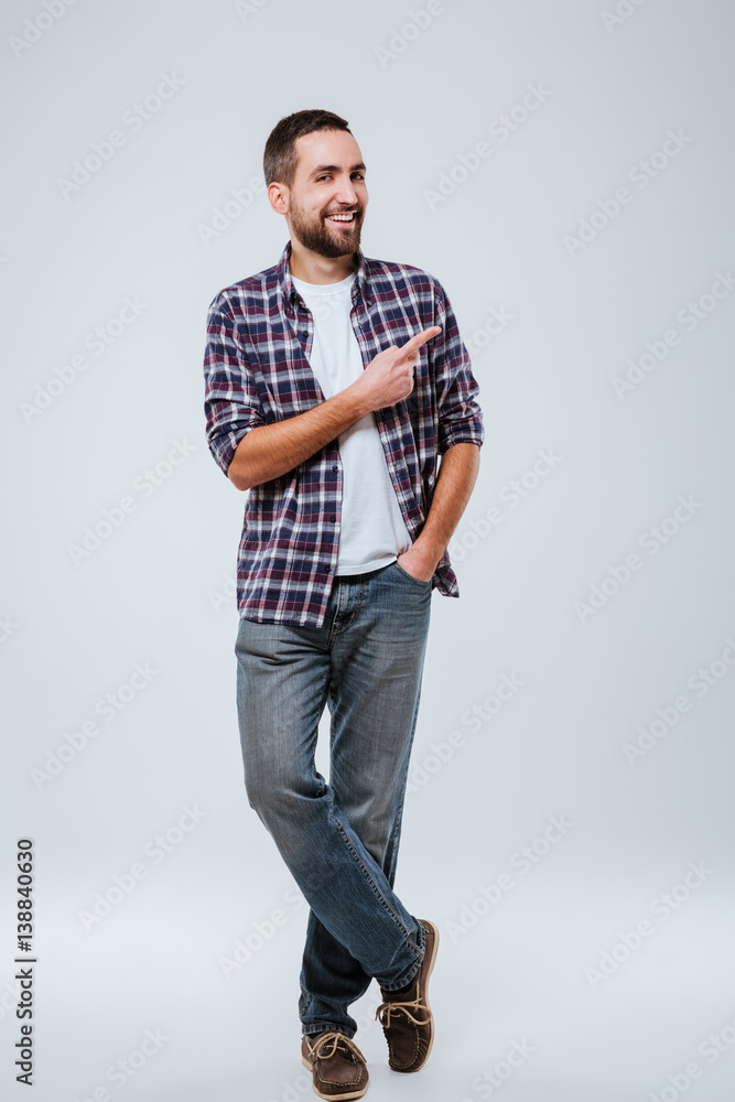 Full length portrait of Bearded man in shirt pointing away Full length portrait of Bearded man in shirt pointing away