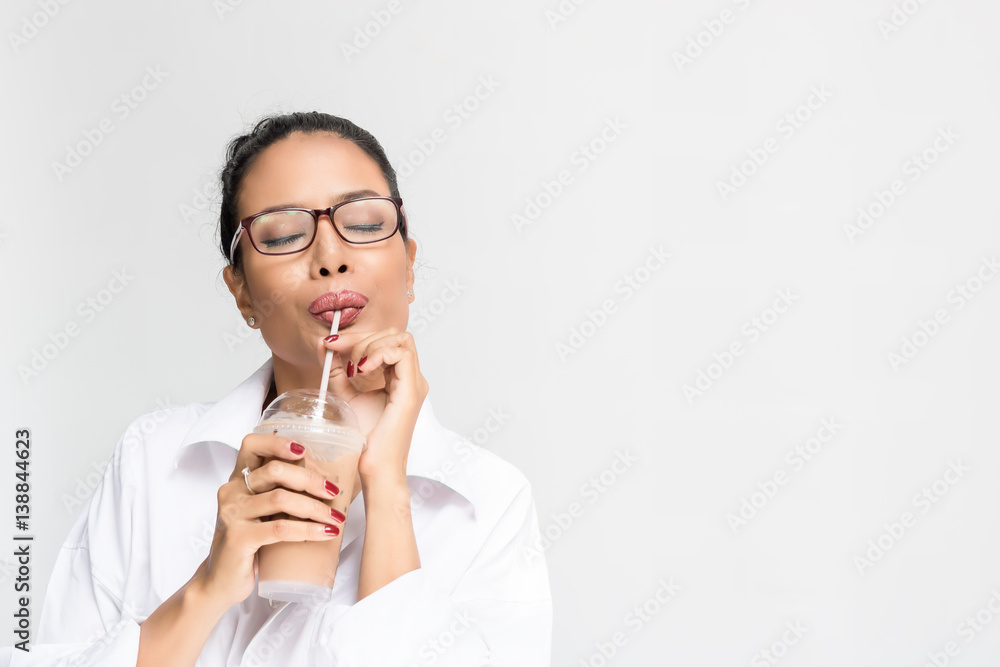 Beautiful woman wearing a white shirt drinking ice coffee on white background Beautiful woman wearing a white shirt drinking ice coffee on white background