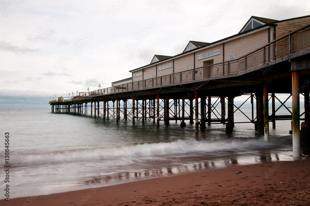 Long exposure image of Teignmouth Victorian pier with reflections in the water. taken in winter.