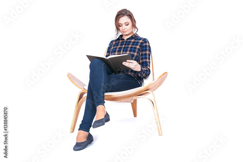 Full length portrait of siting beautiful woman student holding book isolated on a white background