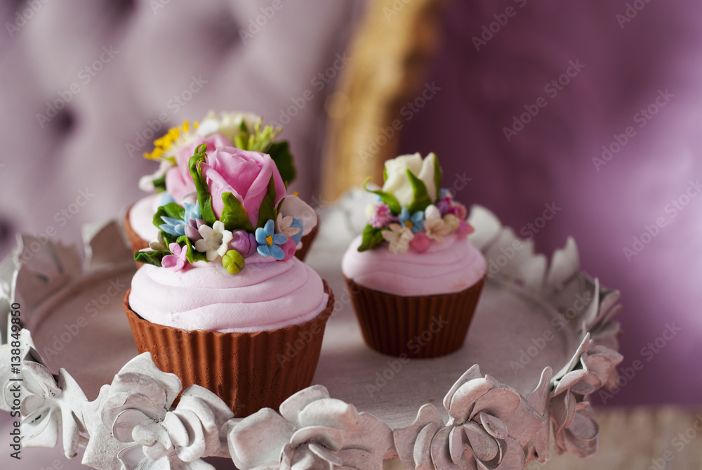 Sweet pink cupcakes decorated with flowers. Copy space. Top of side view
