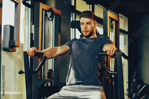 Handsome man in the gym doing chest exercise