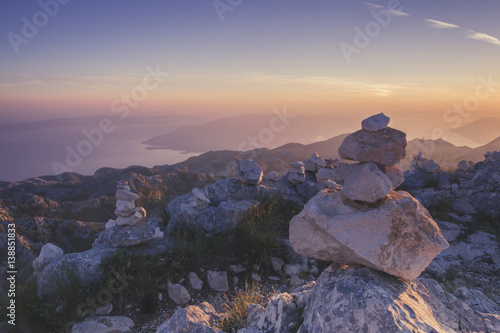 Stones pyramid symbolizing zen  harmony  balance. Seacoast at sunset in the background