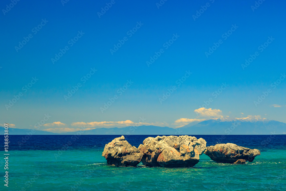 The rocky coast overlooking the turquoise blue sea in warm summer day in Greece, Chalkidiki
