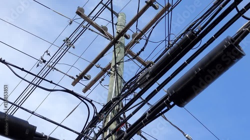 Close up view of a power pole covered in utility cable photo