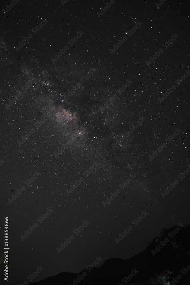 The Milky Way over the mountains in vertical view. Long exposure photograph.