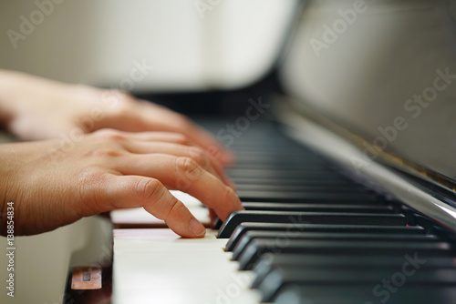 Scene of pianist hands from beside angle with shallow depth of field playing piano. Selective focused.