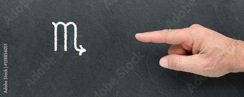 Symbole du Scorpion à la craie et montrer du doigt sur ardoise. Signes du zodiaque
