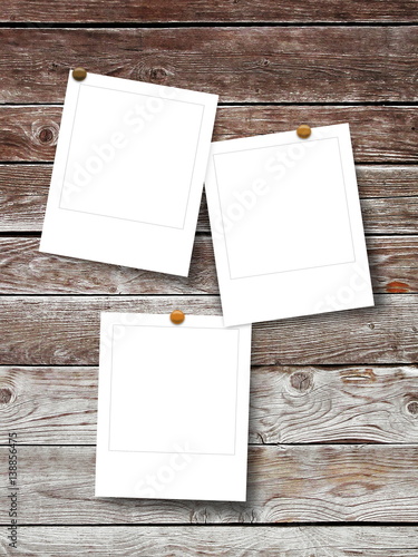 Three blank square photo frames on brown wooden boards background