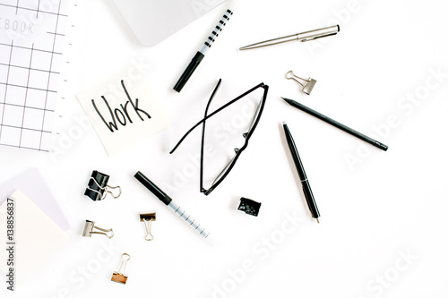 White office desk frame with word Work and supplies. Laptop, notebook, pen, clips, glasses and office supplies on white background. Flat lay, top view, mockup.