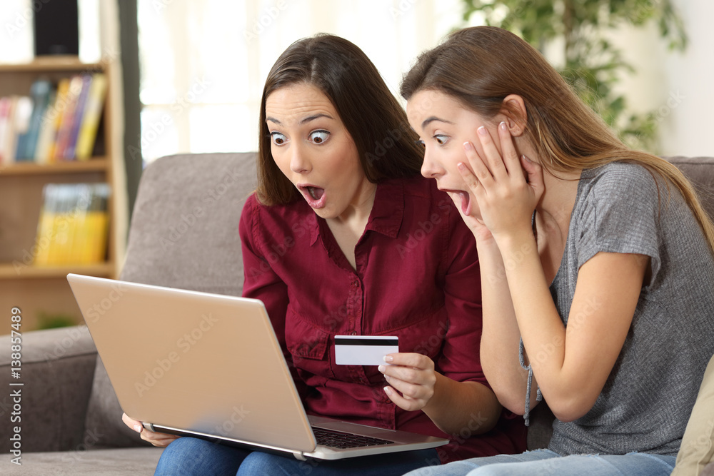 Astonished roommates buying on line at home Astonished roommates buying on line at home