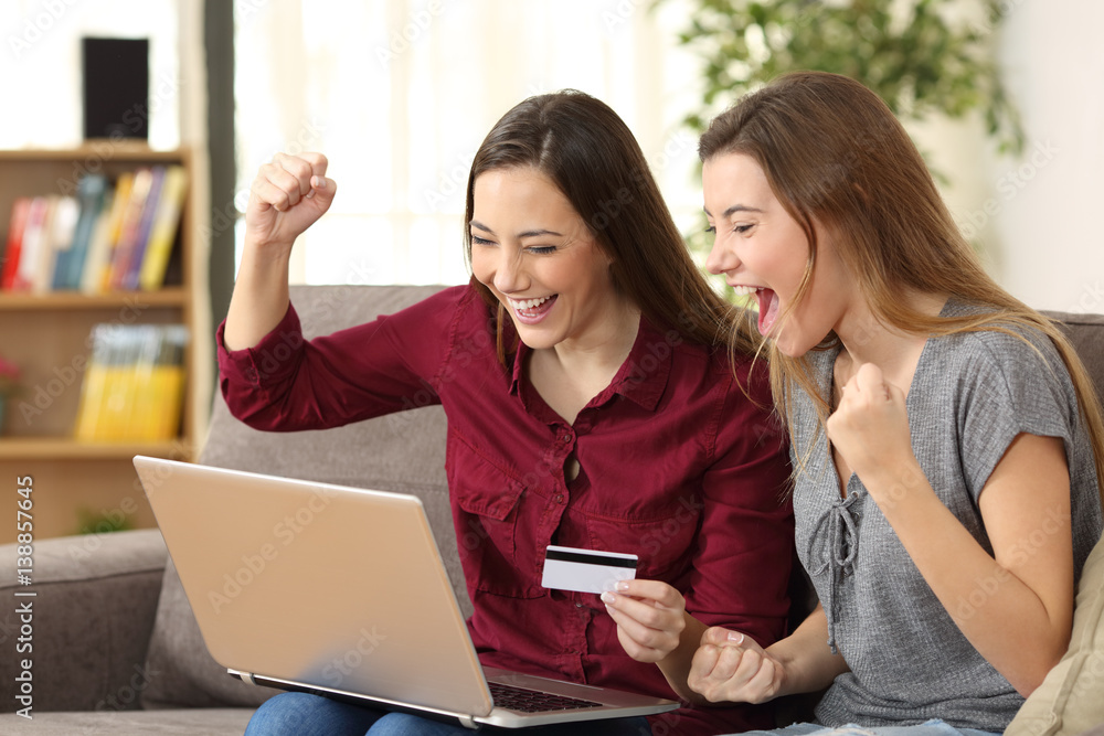 Excited roommates buying on line at home Excited roommates buying on line at home