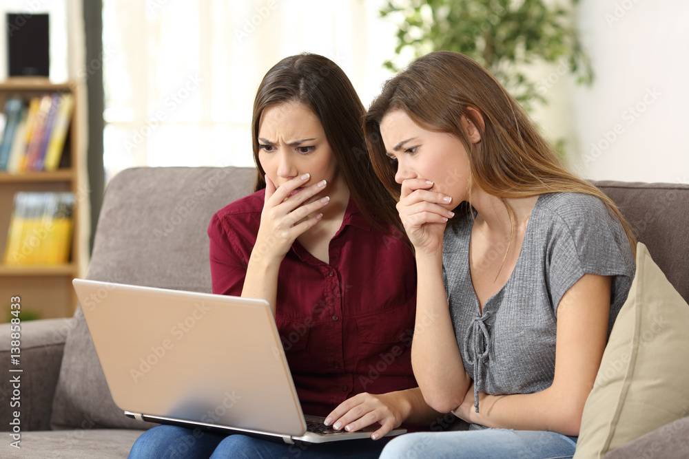 Worried friends watching media content on line Worried friends watching media content on line