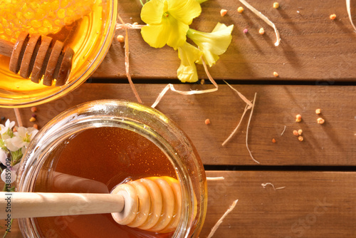 Jar honey with honeycomb on wood table top view photo