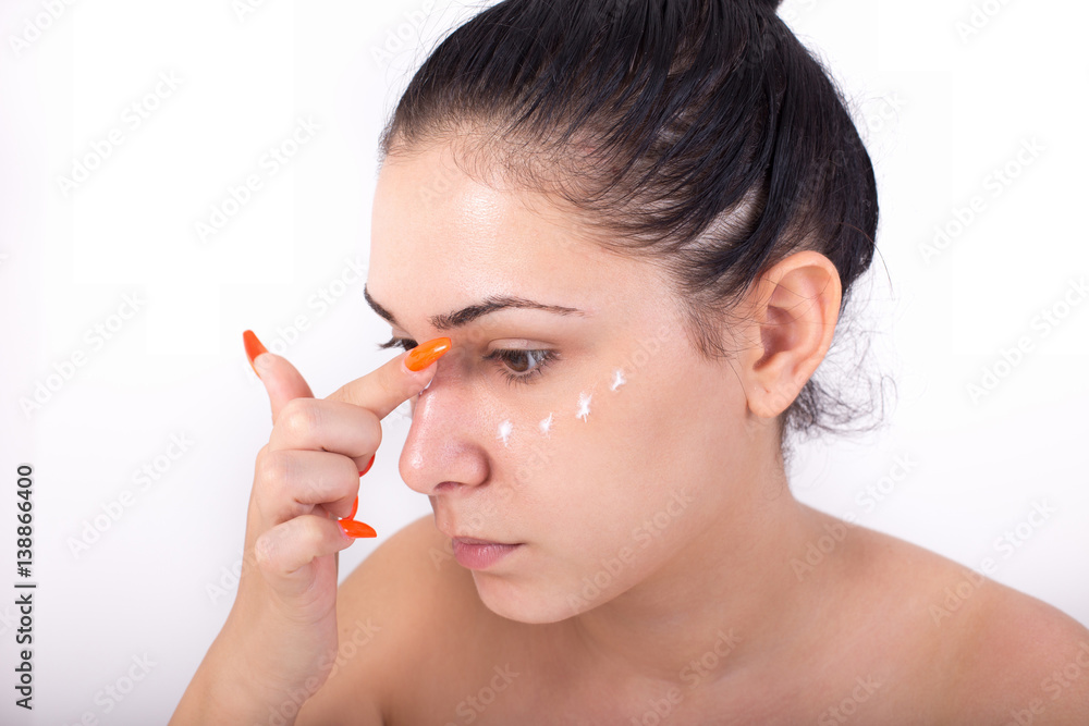 Girl applying facial cream Girl applying facial cream