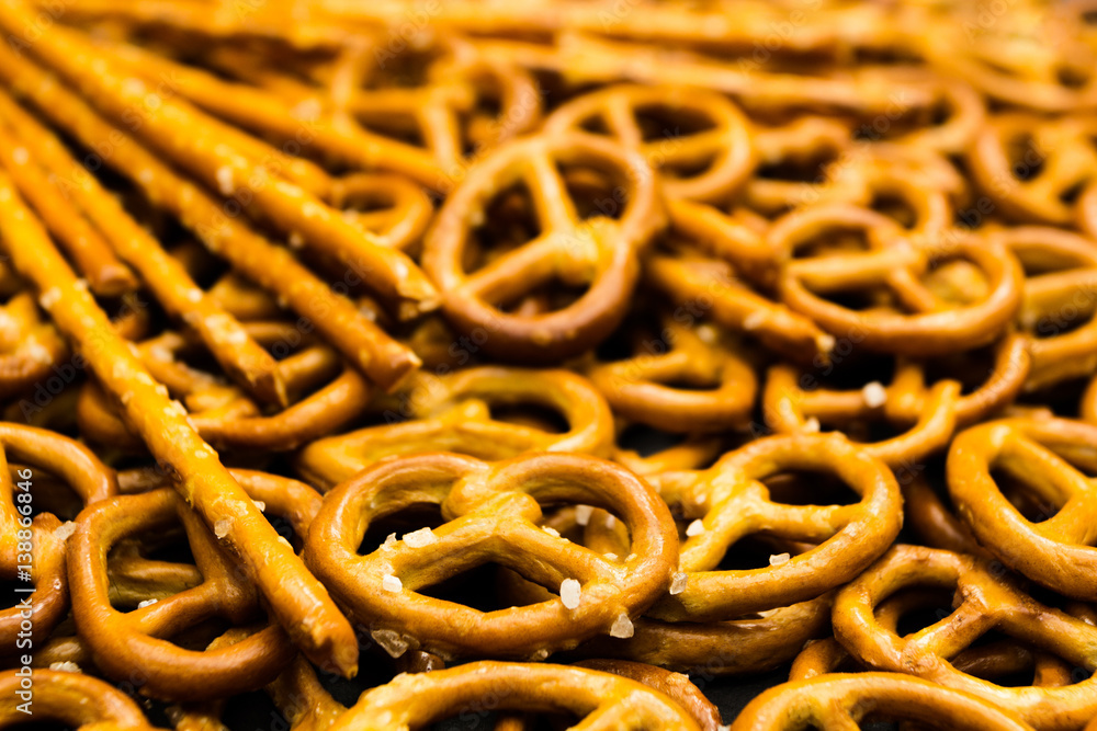 Background texture of salted salty pretzels and mini sticks in the traditional form of the hinge assembly Background texture of salted salty pretzels and mini sticks in the traditional form of the hinge assembly