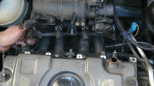 Car mechanic examine fuel injection of gasoline engine