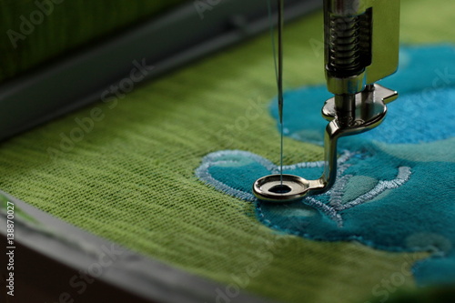 Embroidery with embroidery machine - comic dog application - stitiching details - background and foreground blanked out blurry 