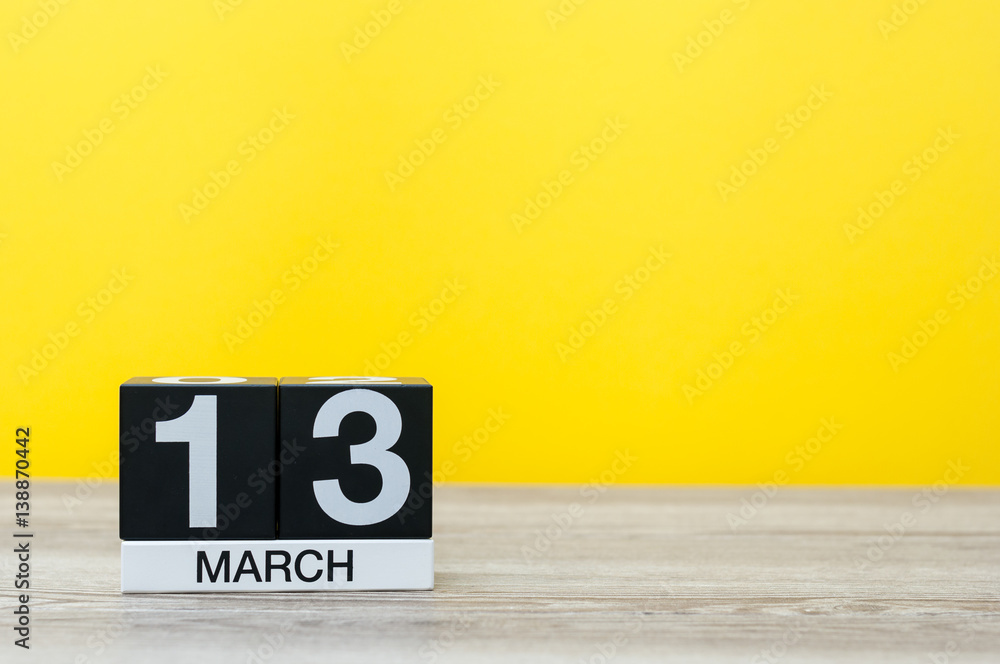 March 13th. Day 13 of month, calendar on table with yellow background. Spring time, empty space for text March 13th. Day 13 of month, calendar on table with yellow background. Spring time, empty space for text