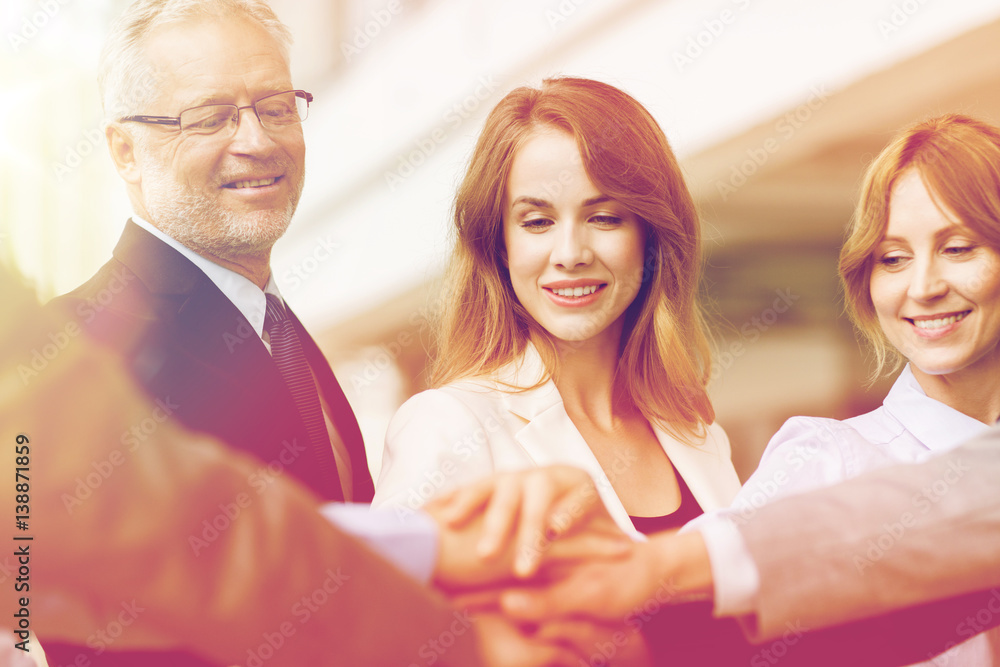 business people putting hands on top in office business people putting hands on top in office