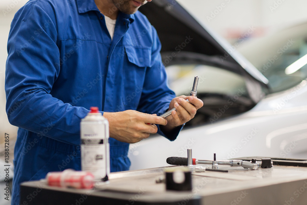 mechanic man with wrench repairing car at workshop mechanic man with wrench repairing car at workshop