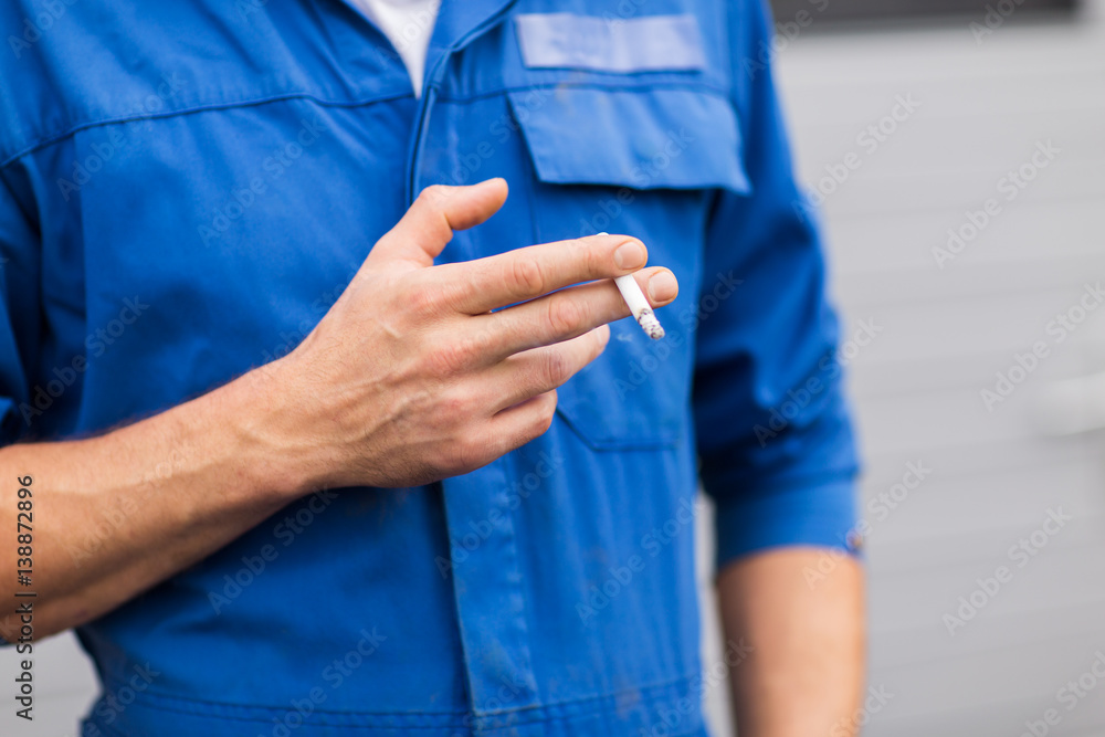 close up of auto mechanic smoking cigarette close up of auto mechanic smoking cigarette