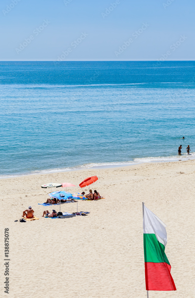 The Black Sea shore, blue clear water, beach with sand, umbrellas and sunbeds. Albena, Bulgaria The Black Sea shore, blue clear water, beach with sand, umbrellas and sunbeds. Albena, Bulgaria